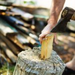 Carefully chopping firewood kindling with hatchet